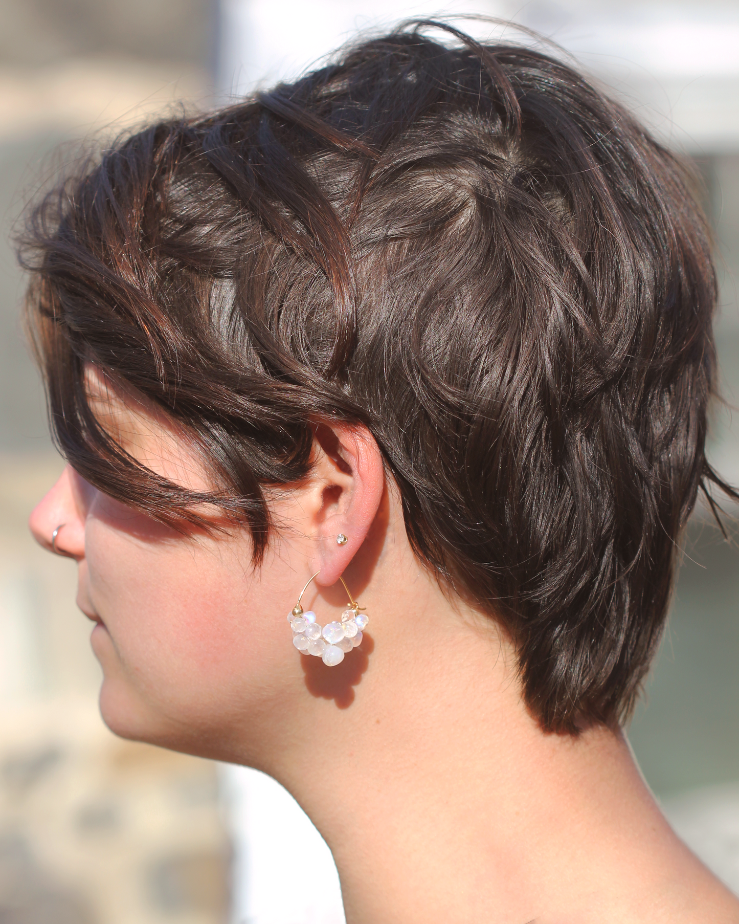woman wearing hoop earrings with rainbow moonstones