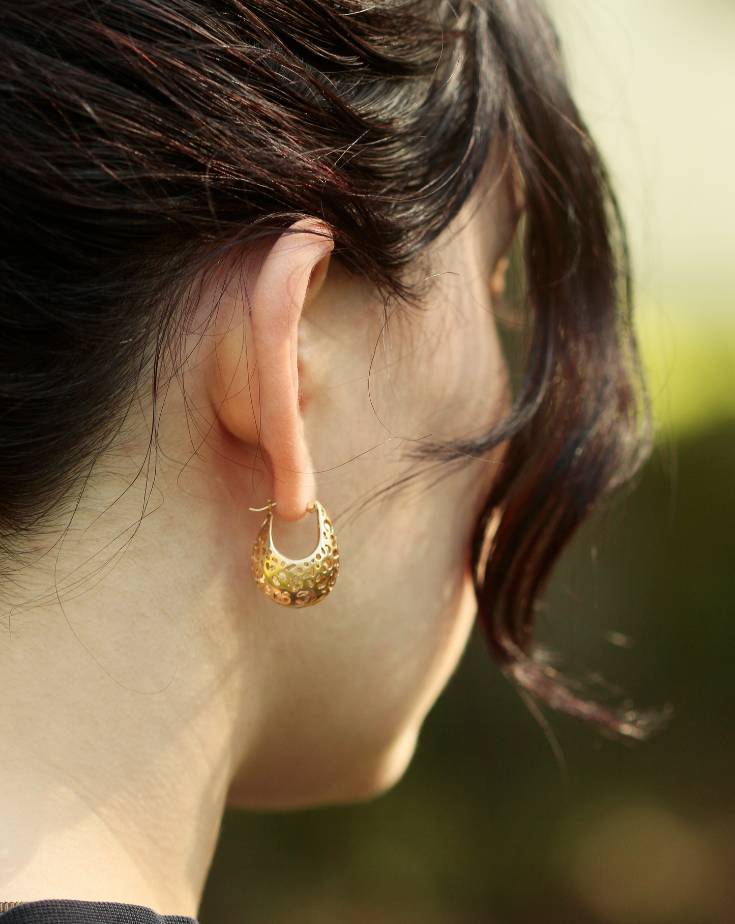 girl wearing gold hoop earrings with leopard print cutouts