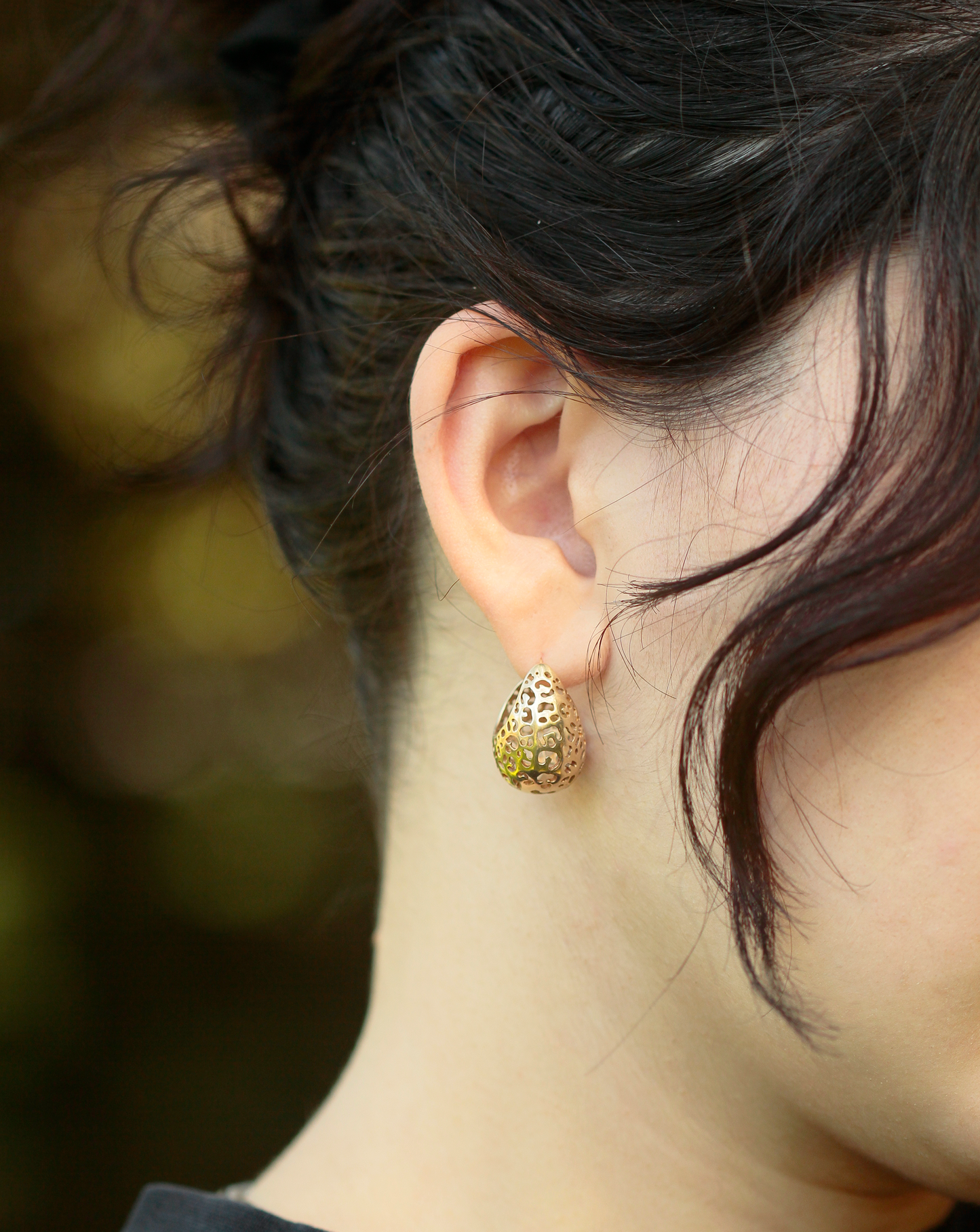 girl wearing gold hoop earrings with leopard print cutouts