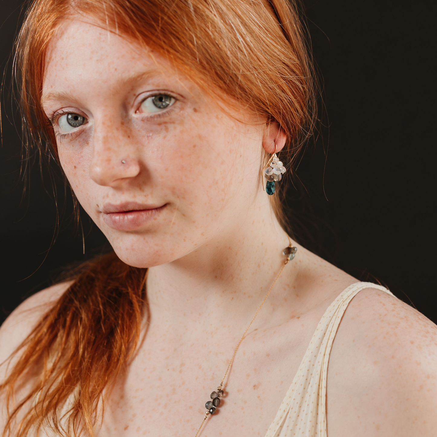 Model wearing Small Plumage Earrings featuring handpicked ombre gemstones, and elongated ear wires