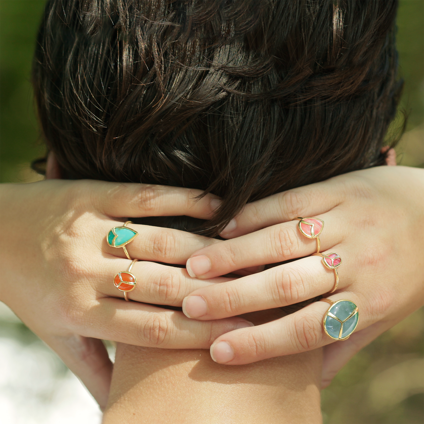 
                  
                    Woman with her hands behind her head, wearing a variety of rings
                  
                