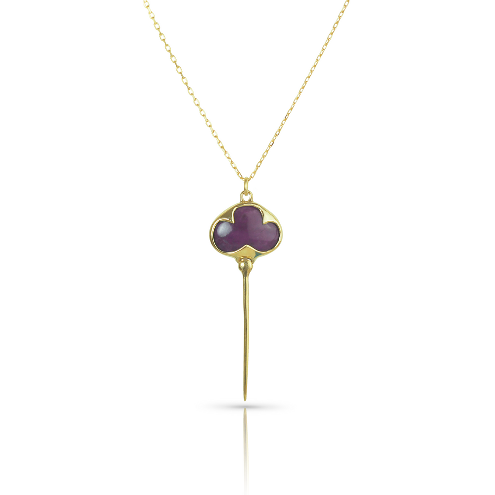 Yellow gold necklace with bezel set purple sugilite stone, and an elongated gold stingray tail dangling from the bottom, on a dainty gold chain